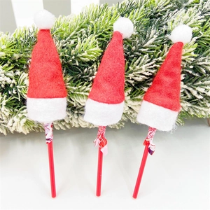 Detailed view of three mini red and white Christmas lollipop hats on decorative sticks