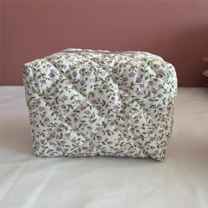 Detail of floral cotton makeup bag with purple flowers and diamond quilted texture