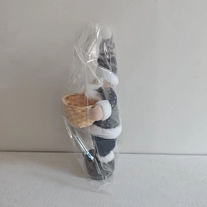 Detail of grey Nordic Christmas gnome in clear packaging with woven basket and fabric hat