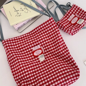 Close-up of red and white plaid tote bag set with cherry logo and adjustable grey strap