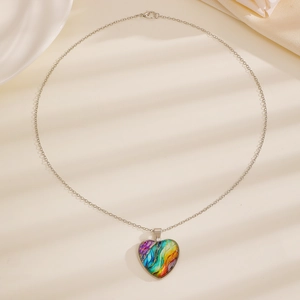 Detailopname van hartvormige hanger met kleurrijke texturen aan zilveren ketting