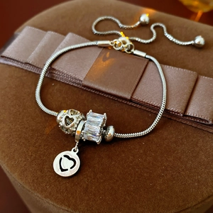 Detail of adjustable silver beaded bracelet with heart charm and cubic zirconia inlay