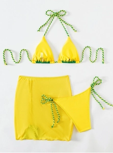 Detailed flat lay of bright yellow three-piece bikini set with neon woven straps