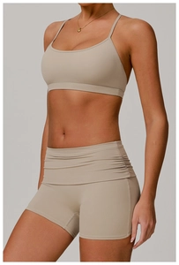 Detail of high-waist ruched shorts and thin strap sports bra set in khaki earth tone