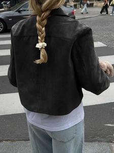 Rear view of a black faux suede jacket featuring minimalist stitching and a tailored fit