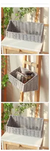 Detail of grey woven cotton rope wall basket with metal hooks for bedside storage