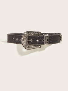 Detail of vintage western belt with crocodile texture and star embossed metal buckle