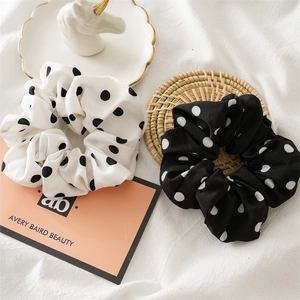 Detailed view of black and white polka dot fabric scrunchies with elegant bow ties