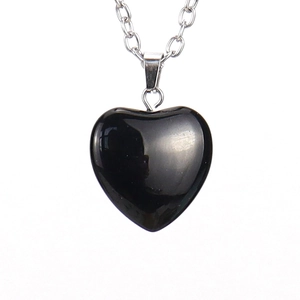 Detailed view of black faceted heart stone pendant with delicate silver chain