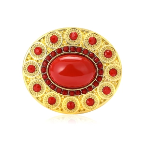 Vintage gold oval brooch featuring a large red center stone and ruby-colored rhinestones