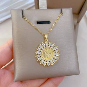 Detail of gold titanium necklace with sparkling zircon ring and Virgin Mary pendant