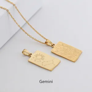 Macro view of gold Gemini zodiac pendant with tarot-style sun and moon engravings