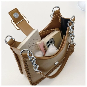 Internal view of brown leather bag showing storage space for books and phone