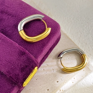 U-shaped two-tone gold and silver stainless steel earrings in a purple velvet gift box