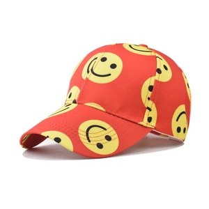 Detail of red cotton baseball cap featuring vibrant all-over yellow smiley face prints