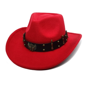 Dettaglio cappello cowboy rosso con cinturino in pelle e stemma con aquila