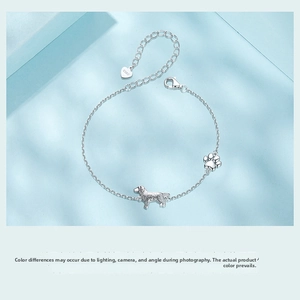 Detailed view of S925 sterling silver dog and paw print pendants on a delicate chain