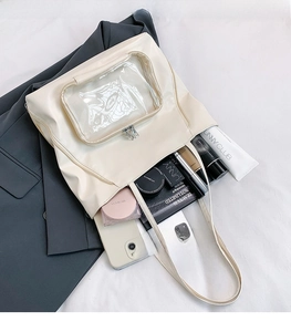 Dettaglio della borsa tote bianco crema con tasca frontale in PVC e grande capacità
