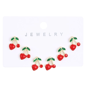 Detail view of 3 pairs of red cherry stud earrings with gold plating on jewelry card