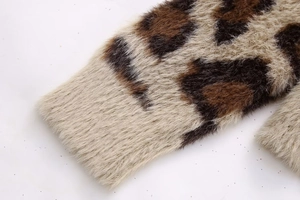Detaillierte Makroaufnahme der Webpelz-Textur und des Leopardenmusters auf Strickjacke