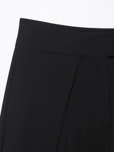 Close-up of black wide-leg trousers showing waistband, zipper fly, and pleat stitching