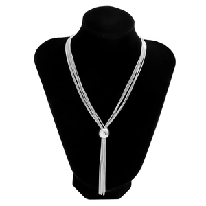 Detail of silver multilayer punk chain necklace with spherical pendants on a black background