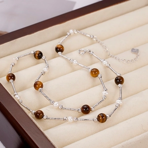 925 silver tiger eye and pearl necklace displayed on a beige velvet jewelry tray