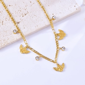 Elegant gold angel pendant necklace with clear zircon stones on a textured stone surface