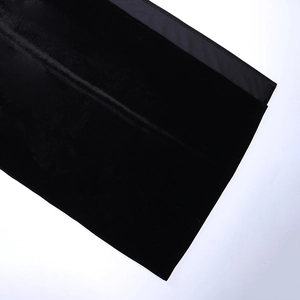Détail du patchwork en velours et tissu uni sur cette robe noire sexy à fente