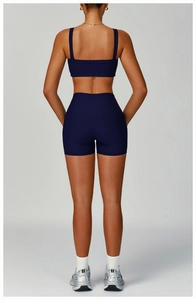 Detail of navy blue ribbed yoga set featuring open back bra and high-waist shorts