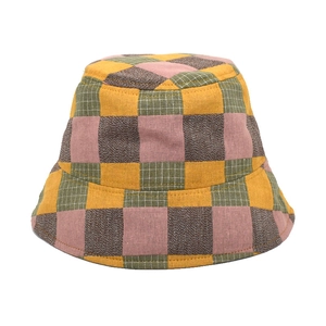 Detail of checkered bucket hat featuring yellow and green cotton fabric stitching