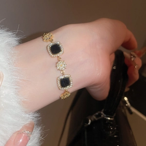 Détail macro du bracelet plaqué or 18k avec onyx noir carré et étoiles de zircon brillants