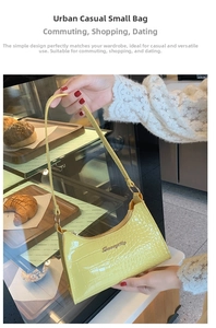 Detail of a bright yellow crocodile pattern underarm bag with gold metal logo and zipper