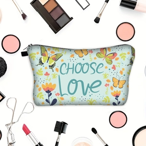 Floral butterfly makeup bag with Choose Love print and cosmetics on white background