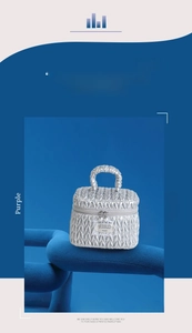Detail of silver quilted cosmetic bag featuring woven texture and pearl zipper pulls
