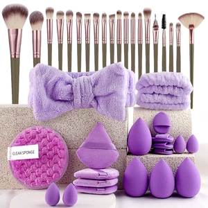 Detailed set of purple makeup sponges, brushes, and soft headband on a stone base