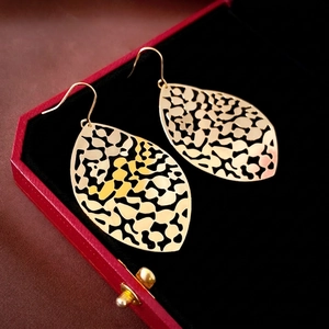Elegant gold cutout leaf tassel drop earrings on black velvet jewelry display box