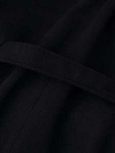 Detailed macro view of black wool coat fabric texture and matching waist belt
