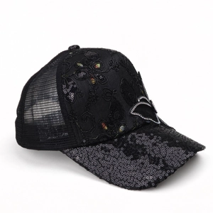 Detail view of a black mesh baseball cap featuring sequined brim and floral embroidery