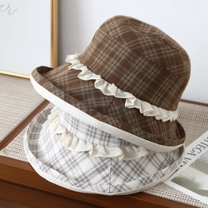 Detail of vintage plaid bucket hats with delicate white lace trim on a wooden surface