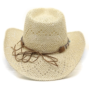 Close-up of woven straw cowboy hat with turquoise beads and brown leather strap detail