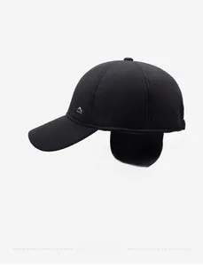 Detail view of winter baseball cap with ear flaps and metal mountain badge