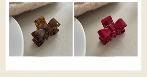 Bow-shaped hair claw clips in tortoise and pitaya pink styles on a textured backdrop