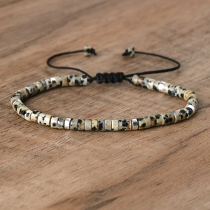 Verstelbare geweven armband met beige gespikkelde natuurstenen kralen en zilveren ringen