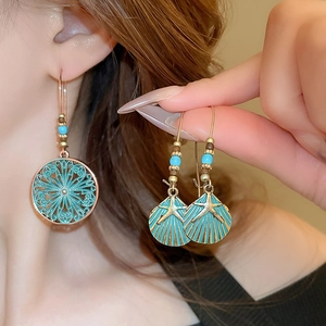 Close-up of bohemian earrings with mandala patterns, starfish shell motifs and beads