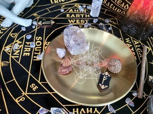 Top view of gold ritual tray with crystals and runes on a black zodiac altar cloth