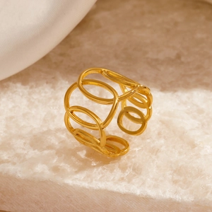 Minimalist gold plated hollow geometric ring with crossed oval rings on stone surface