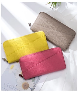Three leather wallets in taupe, yellow and rose red showing pebbled texture and star zipper
