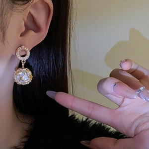 Elegant gold drop earrings with circular pearl studs and hollow sphere pendants