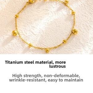 Macro shot of gold titanium steel bead bracelet with polished texture on white stone